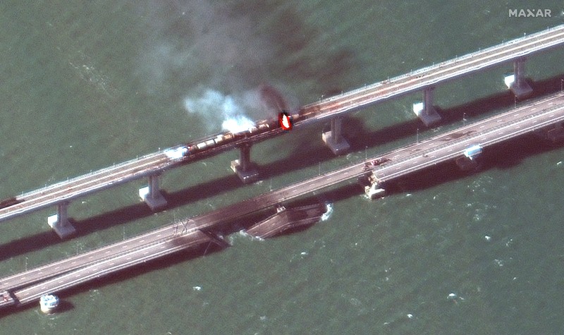 Gambar satelit menunjukkan asap mengepul dari kebakaran di jembatan Kerch di Selat Kerch, Crimea, Sabtu (8/10/2022). Jembatan yang menghubungkan Crimea dengan daratan Rusia itu hancur usai tangki berisi bahan bakar minyak (BBM) diduga meledak di lokasi itu dan menyebabkan 3 orang meninggal. (Maxar Technologies/Handout via REUTERS)