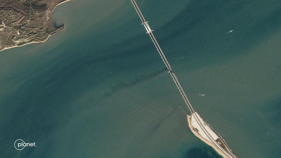 Gambar satelit menunjukkan asap mengepul dari kebakaran di jembatan Kerch di Selat Kerch, Crimea, Sabtu (8/10/2022). Jembatan yang menghubungkan Crimea dengan daratan Rusia itu hancur usai tangki berisi bahan bakar minyak (BBM) diduga meledak di lokasi itu dan menyebabkan 3 orang meninggal. (Maxar Technologies/Handout via REUTERS)