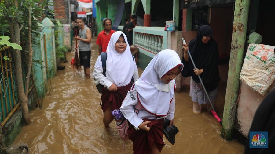 Petugas kepolisian mengevakuasi warga yang terkena banjir di kawasan Kebon Pala, Jakarta Timur, Senin, (10/10/2022). (CNBC Indonesia/Muhammad Sabki)