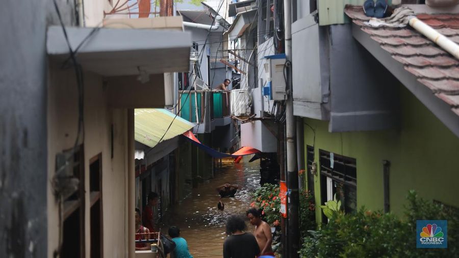 Petugas kepolisian mengevakuasi warga yang terkena banjir di kawasan Kebon Pala, Jakarta Timur, Senin, (10/10/2022). (CNBC Indonesia/Muhammad Sabki)