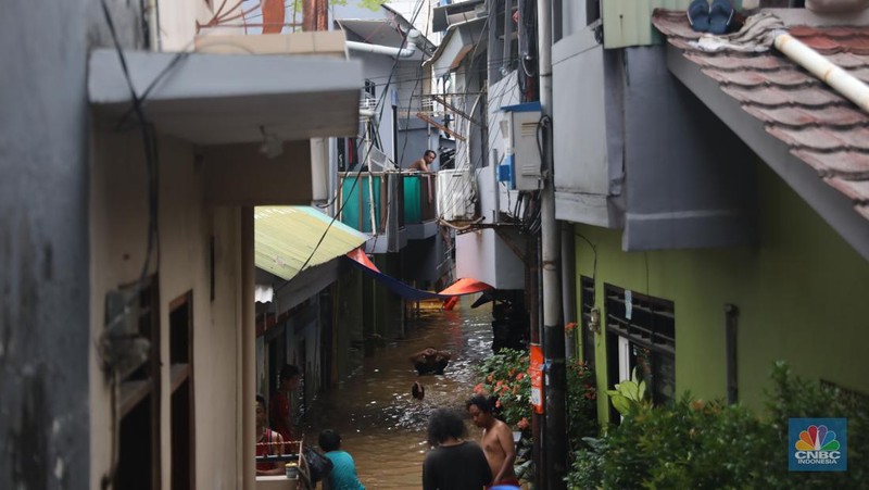 Petugas kepolisian mengevakuasi warga yang terkena banjir di kawasan Kebon Pala, Jakarta Timur, Senin, (10/10/2022). (CNBC Indonesia/Muhammad Sabki)