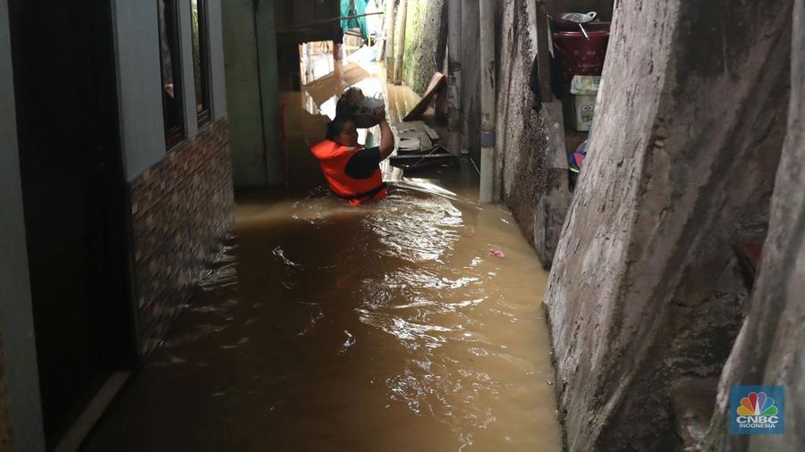 Petugas kepolisian mengevakuasi warga yang terkena banjir di kawasan Kebon Pala, Jakarta Timur, Senin, (10/10/2022). (CNBC Indonesia/Muhammad Sabki)
