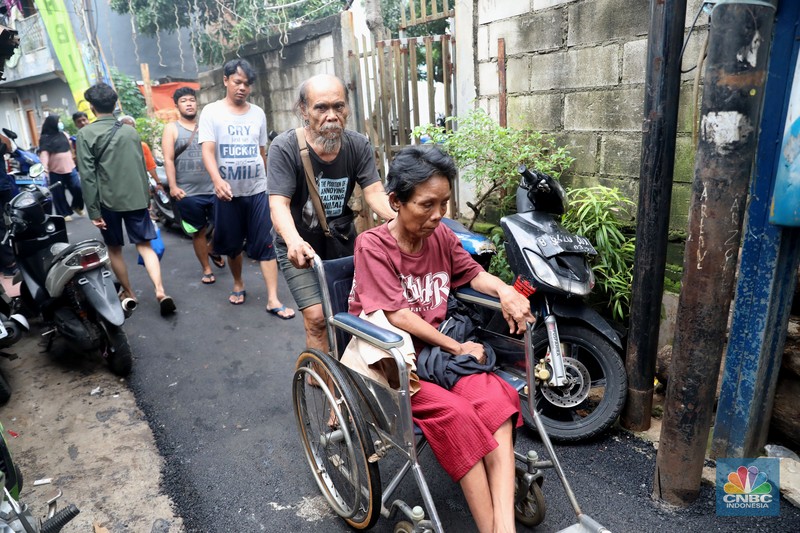 Petugas kepolisian mengevakuasi warga yang terkena banjir di kawasan Kebon Pala, Jakarta Timur, Senin, (10/10/2022). (CNBC Indonesia/Muhammad Sabki)