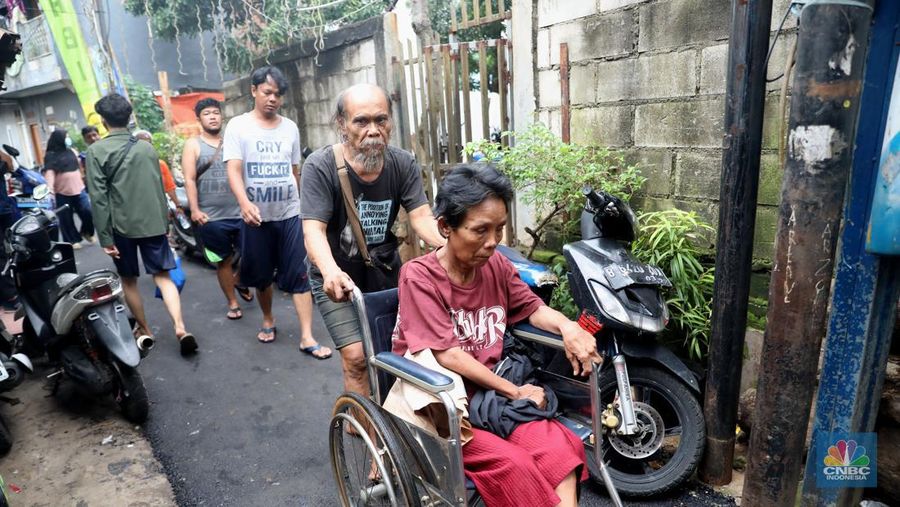 Petugas kepolisian mengevakuasi warga yang terkena banjir di kawasan Kebon Pala, Jakarta Timur, Senin, (10/10/2022). (CNBC Indonesia/Muhammad Sabki)