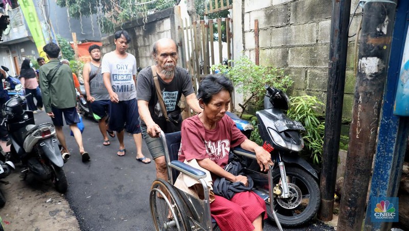 Petugas kepolisian mengevakuasi warga yang terkena banjir di kawasan Kebon Pala, Jakarta Timur, Senin, (10/10/2022). (CNBC Indonesia/Muhammad Sabki)
