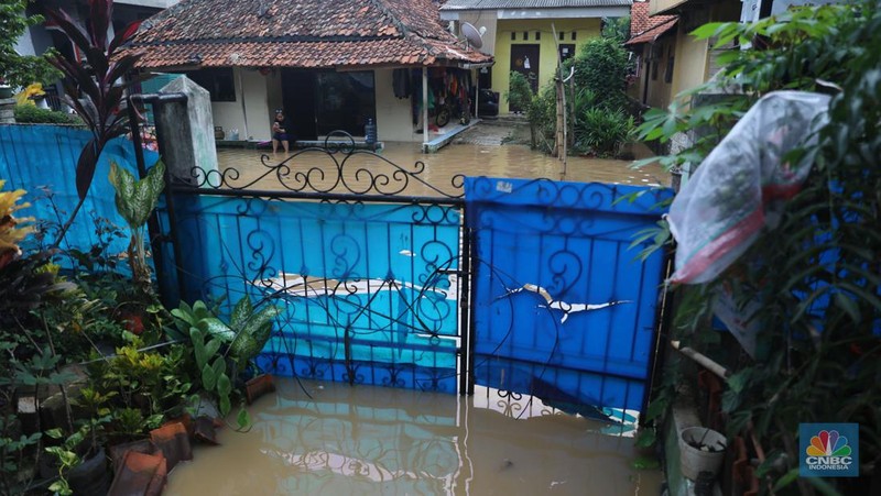 Warga melintas di kawasan banjir di Rawajati, Jakarta, Senin, (10/10). Banjir ini terjadi akibat luapan sungai Ciliwung. (CNBC Indonesia/Muhammad Sabki)