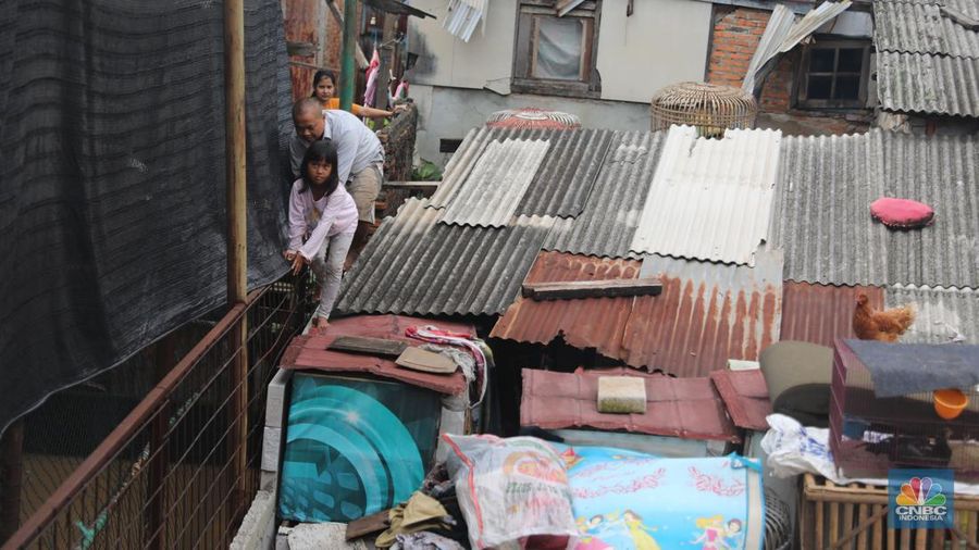 Warga melintas di kawasan banjir di Rawajati, Jakarta, Senin, (10/10). Banjir ini terjadi akibat luapan sungai Ciliwung. (CNBC Indonesia/Muhammad Sabki)