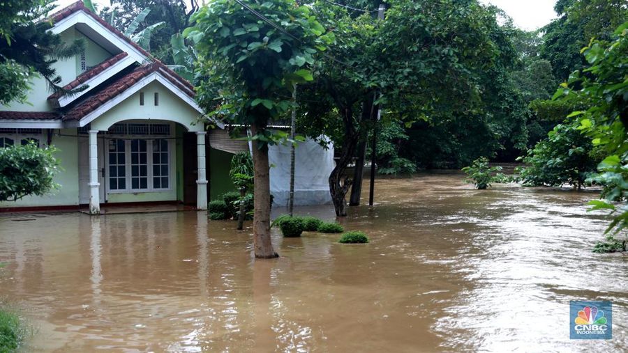 Warga melintas di kawasan banjir di Rawajati, Jakarta, Senin, (10/10). Banjir ini terjadi akibat luapan sungai Ciliwung. (CNBC Indonesia/Muhammad Sabki)