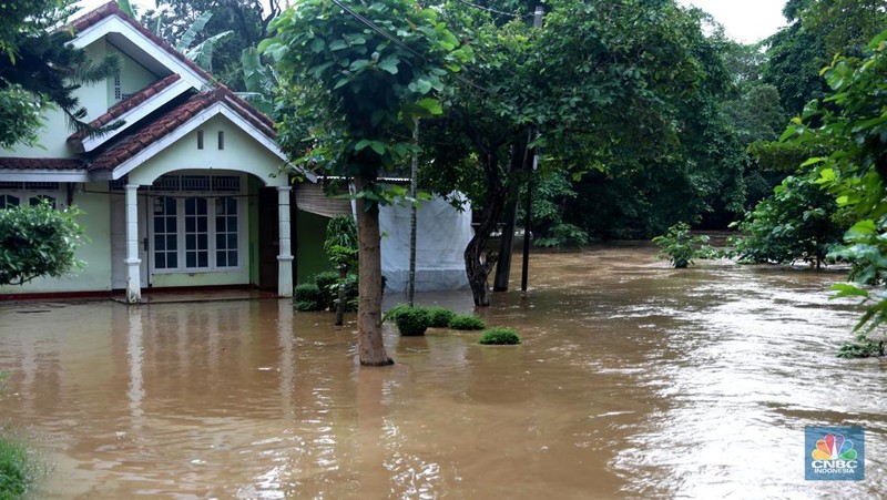 Warga melintas di kawasan banjir di Rawajati, Jakarta, Senin, (10/10). Banjir ini terjadi akibat luapan sungai Ciliwung. (CNBC Indonesia/Muhammad Sabki)