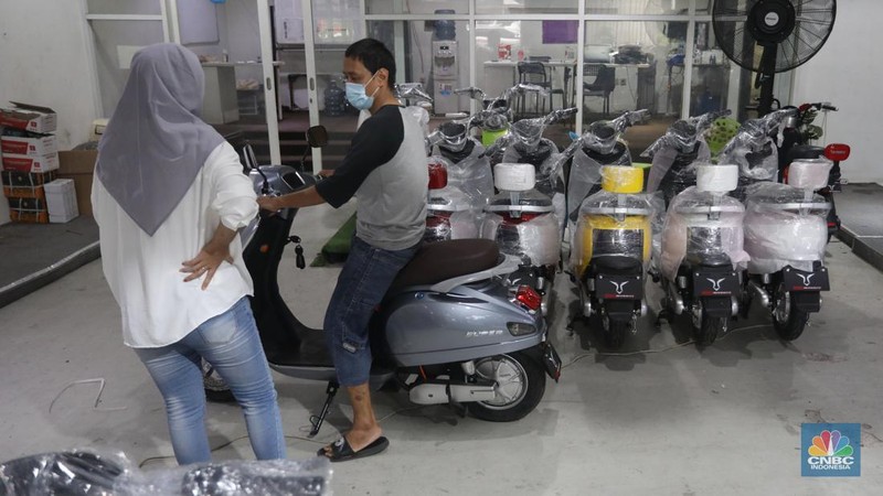 Calon pembeli melihat motor listrik di salah satu showroom di kawasan Jalan Otista Raya, Jakarta Timur, Selasa (11/10/2022). (CNBC Indonesia/Andrean Kristianto)