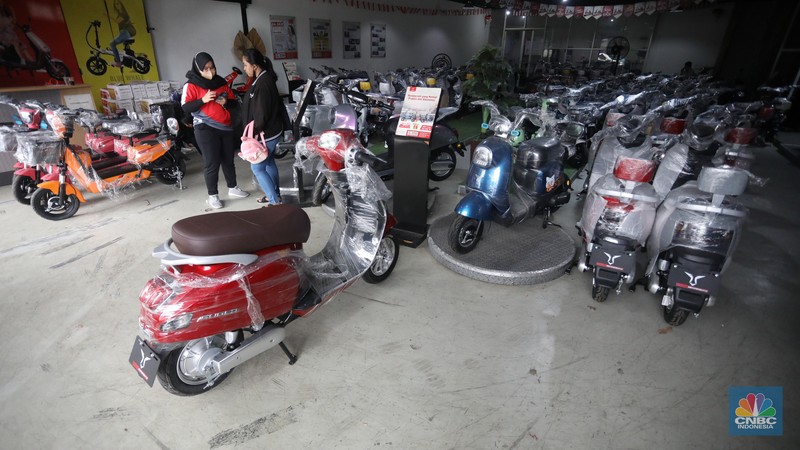 Calon pembeli melihat motor listrik di salah satu showroom di kawasan Jalan Otista Raya, Jakarta Timur, Selasa (11/10/2022). (CNBC Indonesia/Andrean Kristianto)