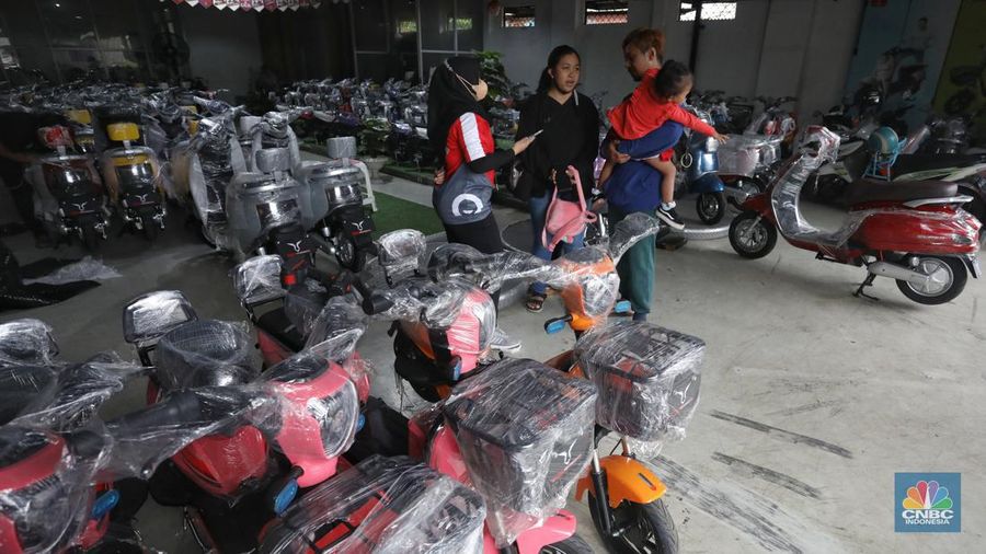 Calon pembeli melihat motor listrik di salah satu showroom di kawasan Jalan Otista Raya, Jakarta Timur, Selasa (11/10/2022). (CNBC Indonesia/Andrean Kristianto)