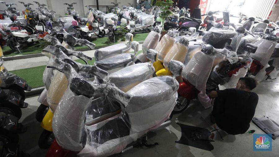 Calon pembeli melihat motor listrik di salah satu showroom di kawasan Jalan Otista Raya, Jakarta Timur, Selasa (11/10/2022). (CNBC Indonesia/Andrean Kristianto)
