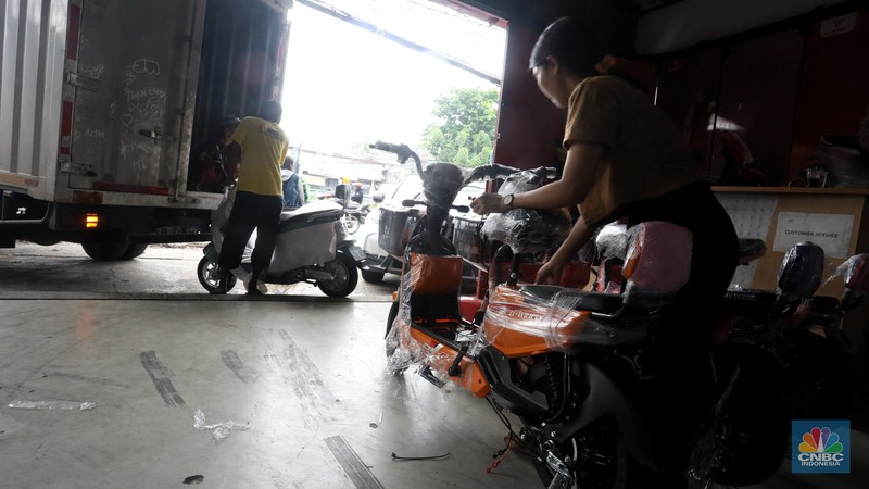 Calon pembeli melihat motor listrik di salah satu showroom di kawasan Jalan Otista Raya, Jakarta Timur, Selasa (11/10/2022). (CNBC Indonesia/Andrean Kristianto)