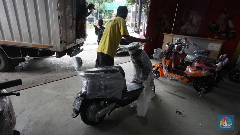 Calon pembeli melihat motor listrik di salah satu showroom di kawasan Jalan Otista Raya, Jakarta Timur, Selasa (11/10/2022). (CNBC Indonesia/Andrean Kristianto)