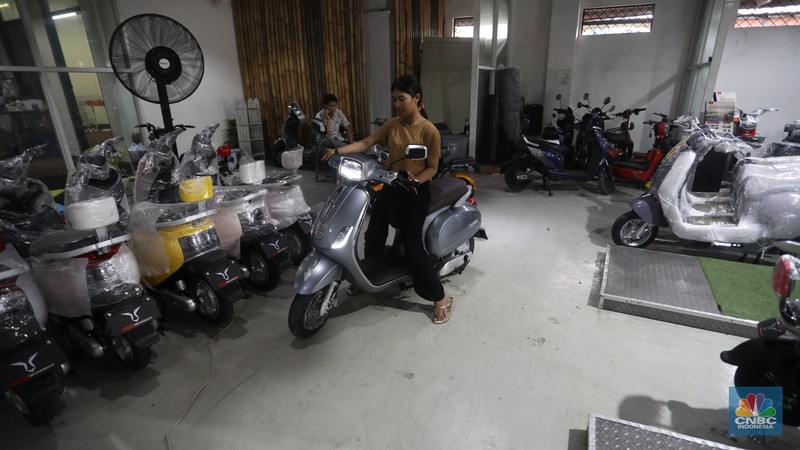 Calon pembeli melihat motor listrik di salah satu showroom di kawasan Jalan Otista Raya, Jakarta Timur, Selasa (11/10/2022). (CNBC Indonesia/Andrean Kristianto)