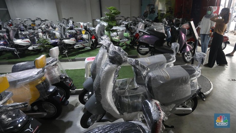 Calon pembeli melihat motor listrik di salah satu showroom di kawasan Jalan Otista Raya, Jakarta Timur, Selasa (11/10/2022). (CNBC Indonesia/Andrean Kristianto)