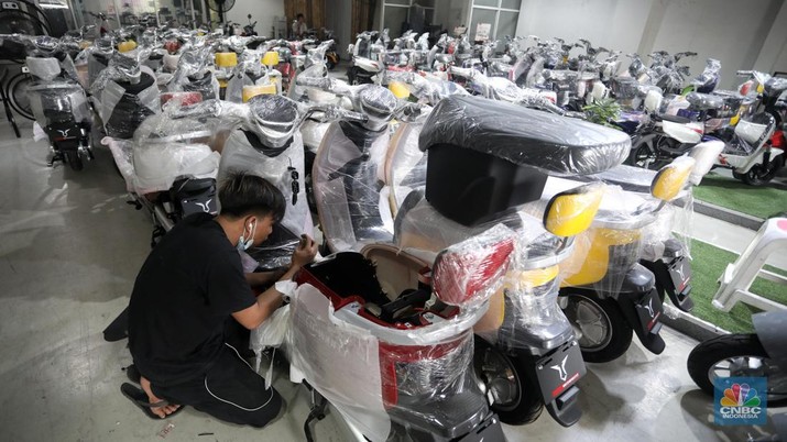 Calon pembeli melihat motor listrik di salah satu showroom di kawasan Jalan Otista Raya, Jakarta Timur, Selasa (11/10/2022). (CNBC Indonesia/Andrean Kristianto)