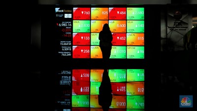 Karyawan melintas di samping layar elektronik yang menunjukkan pergerakan Indeks Harga Saham Gabungan (IHSG) di Bursa Efek Indonesia, Jakarta, Selasa (11/10/2022). (CNBC Indonesia/Andrean Kristianto)