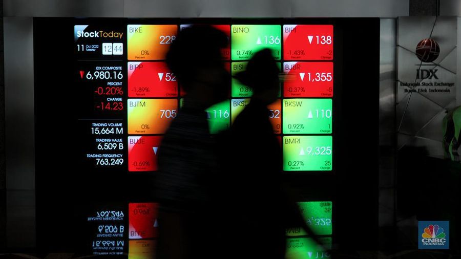 Karyawan melintas di samping layar elektronik yang menunjukkan pergerakan Indeks Harga Saham Gabungan (IHSG) di Bursa Efek Indonesia, Jakarta, Selasa (11/10/2022). (վ/Andrean Kristianto)