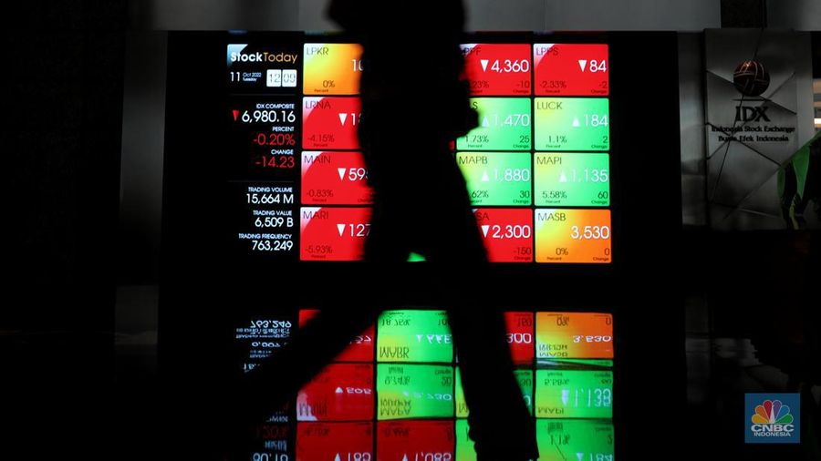 Karyawan melintas di samping layar elektronik yang menunjukkan pergerakan Indeks Harga Saham Gabungan (IHSG) di Bursa Efek Indonesia, Jakarta, Selasa (11/10/2022). (վ/Andrean Kristianto)