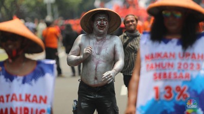 Buruh menggelar aksi teatrikal manusia silver dan pengusaha dalam aksi unjuk rasa gabungan di kawasan Bundaran Patung Kuda, Jakarta, Rabu (12/10/2022). (CNBC Indonesia/Muhammad Sabki)