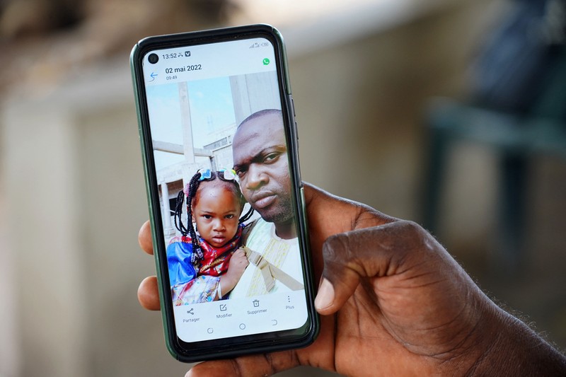 Mariama Kuyateh, 30, holds up a picture of her late son Musawho died from acute kidney failure, in Banjul on October 10, 2022, - Gambian police on October 8, 2022,  announced an investigation into four cough syrups made by the Indian Pharma company Maiden Pharmaceuticals, after the WHO said they could be responsible for the deaths of 66 Gambian children, most under 5-years-old. Nearly half of The Gambia's population lives below the poverty line, according to the World Bank. (Photo by MILAN BERCKMANS / AFP) (Photo by MILAN BERCKMANS/AFP via Getty Images)