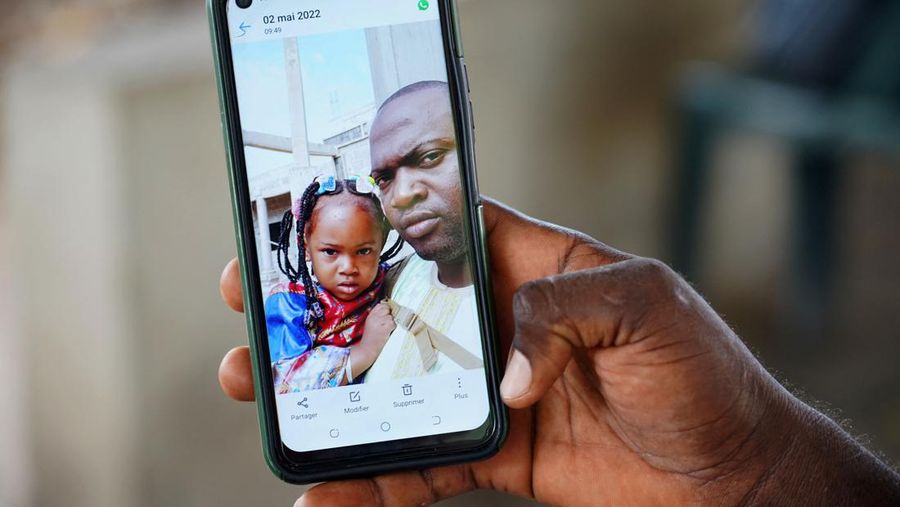 Mariama Kuyateh, 30, holds up a picture of her late son Musawho died from acute kidney failure, in Banjul on October 10, 2022, - Gambian police on October 8, 2022,  announced an investigation into four cough syrups made by the Indian Pharma company Maiden Pharmaceuticals, after the WHO said they could be responsible for the deaths of 66 Gambian children, most under 5-years-old. Nearly half of The Gambia's population lives below the poverty line, according to the World Bank. (Photo by MILAN BERCKMANS / AFP) (Photo by MILAN BERCKMANS/AFP via Getty Images)