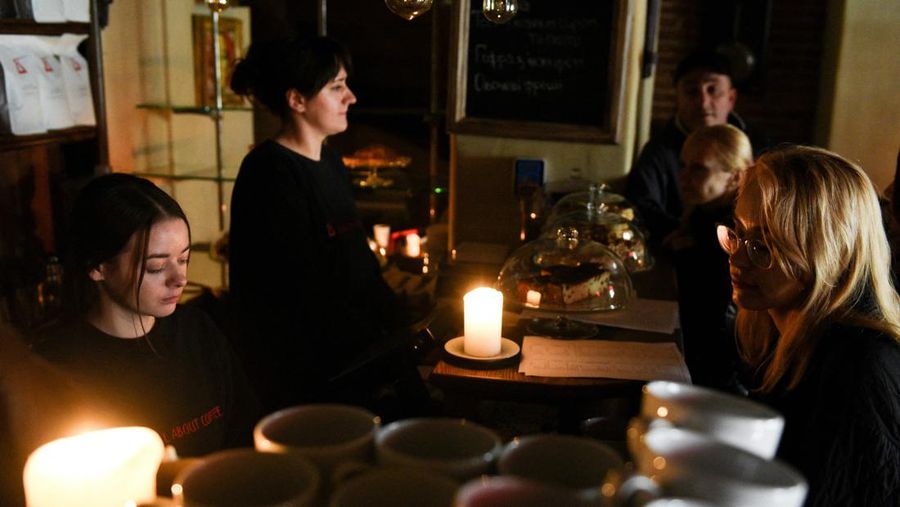 Seorang barista menyiapkan kopi di sebuah kafe tanpa listrik di kota Lviv, Ukraina barat, setelah tiga rudal Rusia menembakkan infrastruktur energi yang ditargetkan pada 11 Oktober 2022. (AFP via Getty Images/YURIY DYACHYSHYN)