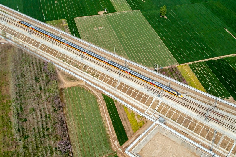 ANYANG, CHINA - APRIL 6, 2022 - Aerial photo show a high-speed railway comprehensive inspection train, which will be exported to Indonesia, passes by on the Jinan-Zhengzhou High-speed Railway in Anyang, Henan Province, China, April 6, 2022. This is the first run of this type of train in China. The Jakarta-Bandung high-speed Railway (JAKarta-Bandung High-Speed Railway) is a high-speed Railway connecting the Greater Jakarta metropolitan area of the Republic of Indonesia with West Java province. It is the first high-speed Railway in Southeast Asia and will be operational in June 2023. The high-speed railway comprehensive inspection train, as an essential and important technical equipment to ensure the safety of high-speed railway line operation, also travels at 350 kilometers per hour. It is used to detect train track condition, measure current and overhead power, test or check communication and signal network and even wheel to track dynamics, etc. It will play a key role in the joint commissioning and trial of jakarta-Bandung high-speed railway and infrastructure maintenance. The Jakarta-Bandung high-speed Railway is a link between China's Belt and Road Initiative and Indonesia's Ocean Fulcrum Strategy. It is a landmark project of practical cooperation between China and Indonesia and also a national strategic project of Indonesia. It connects the capital Jakarta and the fourth largest city Bandung with a length of 142 kilometers and a maximum design speed of 350 kilometers. When completed, the travel time between Jakarta and Bandung will be reduced from more than three hours to 40 minutes. (Photo credit should read Costfoto/Future Publishing via Getty Images)