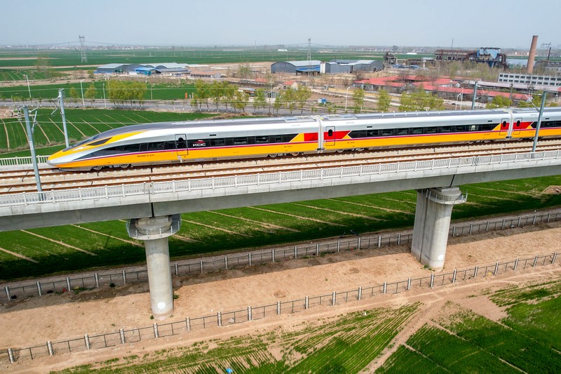 ANYANG, CHINA - APRIL 6, 2022 - Aerial photo show a high-speed railway comprehensive inspection train, which will be exported to Indonesia, passes by on the Jinan-Zhengzhou High-speed Railway in Anyang, Henan Province, China, April 6, 2022. This is the first run of this type of train in China. The Jakarta-Bandung high-speed Railway (JAKarta-Bandung High-Speed Railway) is a high-speed Railway connecting the Greater Jakarta metropolitan area of the Republic of Indonesia with West Java province. It is the first high-speed Railway in Southeast Asia and will be operational in June 2023. The high-speed railway comprehensive inspection train, as an essential and important technical equipment to ensure the safety of high-speed railway line operation, also travels at 350 kilometers per hour. It is used to detect train track condition, measure current and overhead power, test or check communication and signal network and even wheel to track dynamics, etc. It will play a key role in the joint commissioning and trial of jakarta-Bandung high-speed railway and infrastructure maintenance. The Jakarta-Bandung high-speed Railway is a link between China's Belt and Road Initiative and Indonesia's Ocean Fulcrum Strategy. It is a landmark project of practical cooperation between China and Indonesia and also a national strategic project of Indonesia. It connects the capital Jakarta and the fourth largest city Bandung with a length of 142 kilometers and a maximum design speed of 350 kilometers. When completed, the travel time between Jakarta and Bandung will be reduced from more than three hours to 40 minutes. (Photo credit should read Costfoto/Future Publishing via Getty Images)