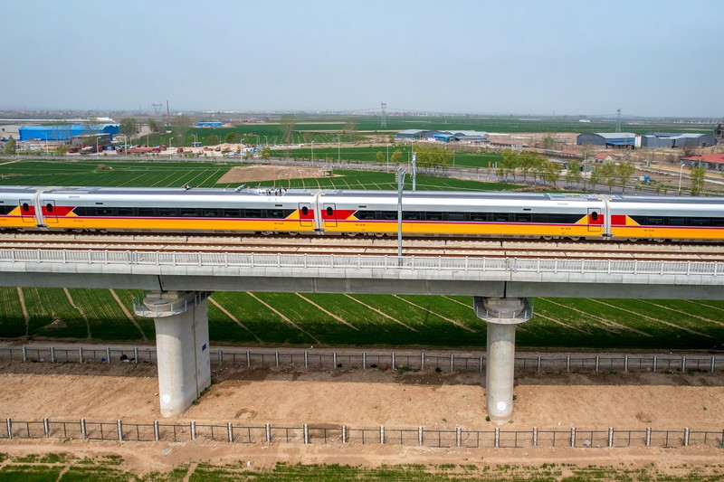 ANYANG, CHINA - APRIL 6, 2022 - Aerial photo show a high-speed railway comprehensive inspection train, which will be exported to Indonesia, passes by on the Jinan-Zhengzhou High-speed Railway in Anyang, Henan Province, China, April 6, 2022. This is the first run of this type of train in China. The Jakarta-Bandung high-speed Railway (JAKarta-Bandung High-Speed Railway) is a high-speed Railway connecting the Greater Jakarta metropolitan area of the Republic of Indonesia with West Java province. It is the first high-speed Railway in Southeast Asia and will be operational in June 2023. The high-speed railway comprehensive inspection train, as an essential and important technical equipment to ensure the safety of high-speed railway line operation, also travels at 350 kilometers per hour. It is used to detect train track condition, measure current and overhead power, test or check communication and signal network and even wheel to track dynamics, etc. It will play a key role in the joint commissioning and trial of jakarta-Bandung high-speed railway and infrastructure maintenance. The Jakarta-Bandung high-speed Railway is a link between China's Belt and Road Initiative and Indonesia's Ocean Fulcrum Strategy. It is a landmark project of practical cooperation between China and Indonesia and also a national strategic project of Indonesia. It connects the capital Jakarta and the fourth largest city Bandung with a length of 142 kilometers and a maximum design speed of 350 kilometers. When completed, the travel time between Jakarta and Bandung will be reduced from more than three hours to 40 minutes. (Photo credit should read Costfoto/Future Publishing via Getty Images)