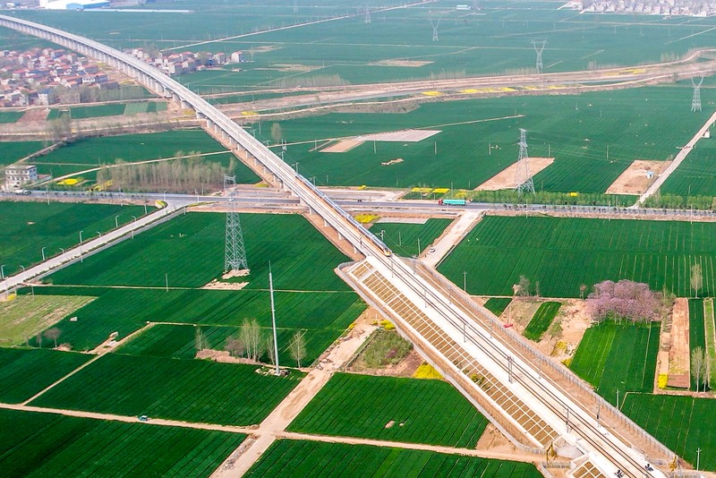 ANYANG, CHINA - APRIL 6, 2022 - Aerial photo show a high-speed railway comprehensive inspection train, which will be exported to Indonesia, passes by on the Jinan-Zhengzhou High-speed Railway in Anyang, Henan Province, China, April 6, 2022. This is the first run of this type of train in China. The Jakarta-Bandung high-speed Railway (JAKarta-Bandung High-Speed Railway) is a high-speed Railway connecting the Greater Jakarta metropolitan area of the Republic of Indonesia with West Java province. It is the first high-speed Railway in Southeast Asia and will be operational in June 2023. The high-speed railway comprehensive inspection train, as an essential and important technical equipment to ensure the safety of high-speed railway line operation, also travels at 350 kilometers per hour. It is used to detect train track condition, measure current and overhead power, test or check communication and signal network and even wheel to track dynamics, etc. It will play a key role in the joint commissioning and trial of jakarta-Bandung high-speed railway and infrastructure maintenance. The Jakarta-Bandung high-speed Railway is a link between China's Belt and Road Initiative and Indonesia's Ocean Fulcrum Strategy. It is a landmark project of practical cooperation between China and Indonesia and also a national strategic project of Indonesia. It connects the capital Jakarta and the fourth largest city Bandung with a length of 142 kilometers and a maximum design speed of 350 kilometers. When completed, the travel time between Jakarta and Bandung will be reduced from more than three hours to 40 minutes. (Photo credit should read Costfoto/Future Publishing via Getty Images)