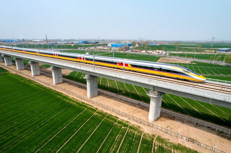 ANYANG, CHINA - APRIL 6, 2022 - Aerial photo show a high-speed railway comprehensive inspection train, which will be exported to Indonesia, passes by on the Jinan-Zhengzhou High-speed Railway in Anyang, Henan Province, China, April 6, 2022. This is the first run of this type of train in China. The Jakarta-Bandung high-speed Railway (JAKarta-Bandung High-Speed Railway) is a high-speed Railway connecting the Greater Jakarta metropolitan area of the Republic of Indonesia with West Java province. It is the first high-speed Railway in Southeast Asia and will be operational in June 2023. The high-speed railway comprehensive inspection train, as an essential and important technical equipment to ensure the safety of high-speed railway line operation, also travels at 350 kilometers per hour. It is used to detect train track condition, measure current and overhead power, test or check communication and signal network and even wheel to track dynamics, etc. It will play a key role in the joint commissioning and trial of jakarta-Bandung high-speed railway and infrastructure maintenance. The Jakarta-Bandung high-speed Railway is a link between China's Belt and Road Initiative and Indonesia's Ocean Fulcrum Strategy. It is a landmark project of practical cooperation between China and Indonesia and also a national strategic project of Indonesia. It connects the capital Jakarta and the fourth largest city Bandung with a length of 142 kilometers and a maximum design speed of 350 kilometers. When completed, the travel time between Jakarta and Bandung will be reduced from more than three hours to 40 minutes. (Photo credit should read Costfoto/Future Publishing via Getty Images)