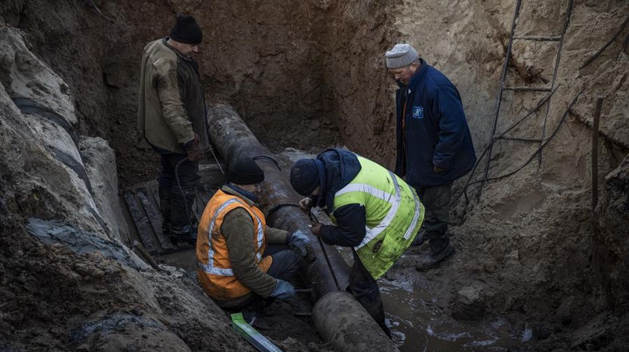 KYIV, UKRAINE - OCTOBER 11: Men fix a pipe in the crater left by a missile strike the day before near Taras Shevchenko National University on October 11, 2022 in Kyiv, Ukraine. Ukraine's emergency services said that 19 people were killed across the country yesterday in a widespread Russian attack on major cities, including the capital. (Photo by Ed Ram/Getty Images)