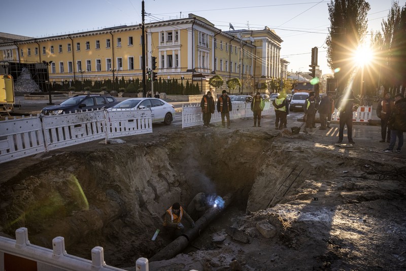 KYIV, UKRAINE - OCTOBER 11: Men fix a pipe in the crater left by a missile strike the day before near Taras Shevchenko National University on October 11, 2022 in Kyiv, Ukraine. Ukraine's emergency services said that 19 people were killed across the country yesterday in a widespread Russian attack on major cities, including the capital. (Photo by Ed Ram/Getty Images)