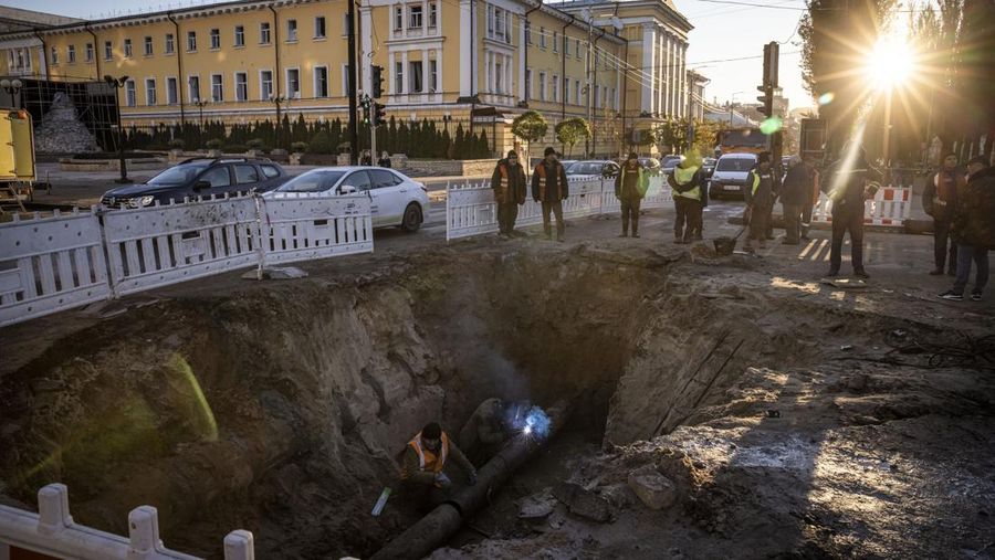 KYIV, UKRAINE - OCTOBER 11: Men fix a pipe in the crater left by a missile strike the day before near Taras Shevchenko National University on October 11, 2022 in Kyiv, Ukraine. Ukraine's emergency services said that 19 people were killed across the country yesterday in a widespread Russian attack on major cities, including the capital. (Photo by Ed Ram/Getty Images)