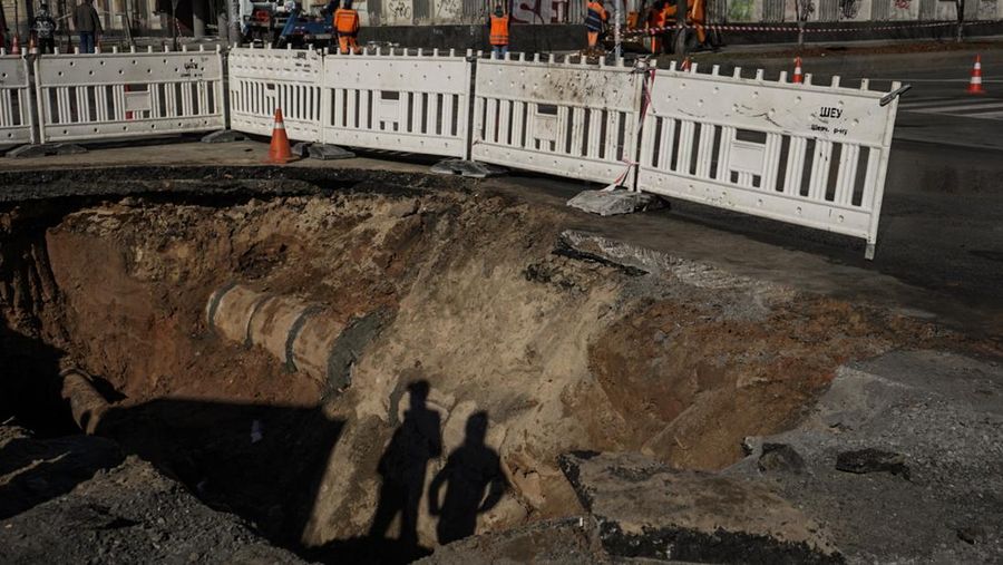 KYIV, UKRAINE - OCTOBER 11: Men fix a pipe in the crater left by a missile strike the day before near Taras Shevchenko National University on October 11, 2022 in Kyiv, Ukraine. Ukraine's emergency services said that 19 people were killed across the country yesterday in a widespread Russian attack on major cities, including the capital. (Photo by Ed Ram/Getty Images)