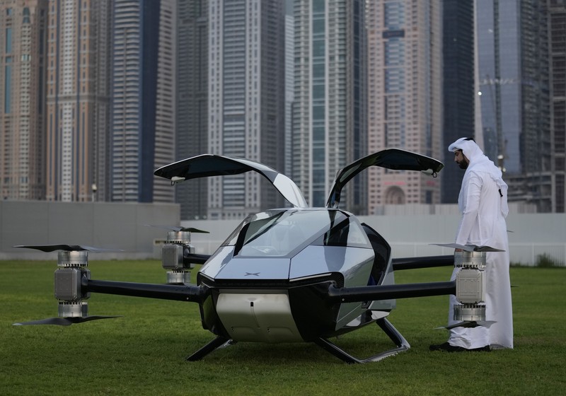 Emirates Flying Taxi People look at the XPeng X2, an electric flying taxi developed by the Guangzhou-based XPeng, Inc's aviation affiliate, being tested in front of the Marina District in Dubai, United Arab Emirates, Monday, Oct. 10, 2022. Monday’s demonstration was held with an empty cockpit, but the company says it carried out a manned flight test last year of the two-passenger vehicle. (AP Photo/Kamran Jebreili)