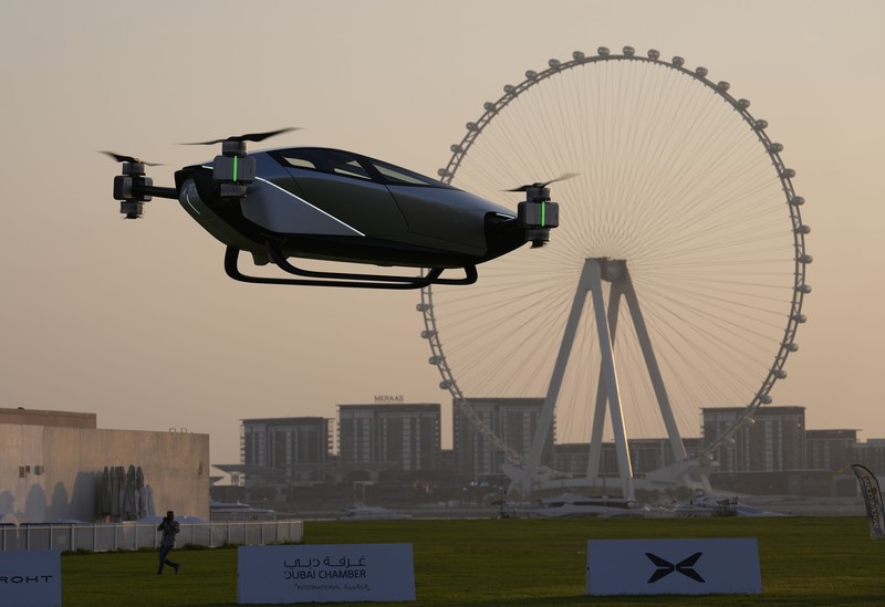 Emirates Flying Taxi People look at the XPeng X2, an electric flying taxi developed by the Guangzhou-based XPeng, Inc's aviation affiliate, being tested in front of the Marina District in Dubai, United Arab Emirates, Monday, Oct. 10, 2022. Monday’s demonstration was held with an empty cockpit, but the company says it carried out a manned flight test last year of the two-passenger vehicle. (AP Photo/Kamran Jebreili)