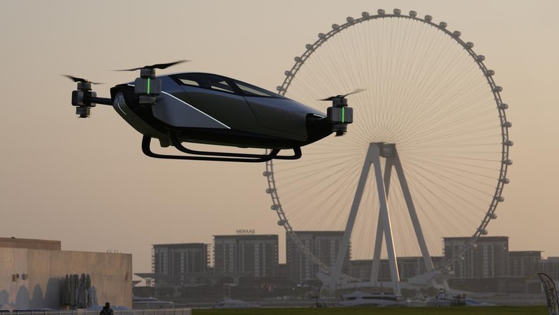 People look at the XPeng X2, an electric flying taxi developed by the Guangzhou-based XPeng, Inc's aviation affiliate, being tested in front of the Marina District in Dubai, United Arab Emirates, Monday, Oct. 10, 2022. Monday’s demonstration was held with an empty cockpit, but the company says it carried out a manned flight test last year of the two-passenger vehicle. (AP Photo/Kamran Jebreili)