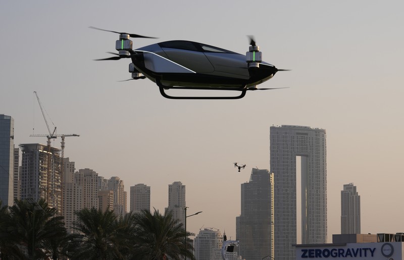 Emirates Flying Taxi People look at the XPeng X2, an electric flying taxi developed by the Guangzhou-based XPeng, Inc's aviation affiliate, being tested in front of the Marina District in Dubai, United Arab Emirates, Monday, Oct. 10, 2022. Monday’s demonstration was held with an empty cockpit, but the company says it carried out a manned flight test last year of the two-passenger vehicle. (AP Photo/Kamran Jebreili)