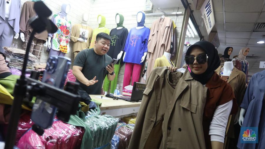 Karyawan mempromosikan pakaian wanita di platfom siaran langsung (live) media sosial di kawasan Pertokoan Tanah Abang, Jakarta Pusat, Kamis (13/10/2022). Di era digital saat ini berbagai cara pedagang mempromosikan barang jualanannya salah satunya dengan platform media sosial. (CNBC Indonesia/Andrean Kristianto)