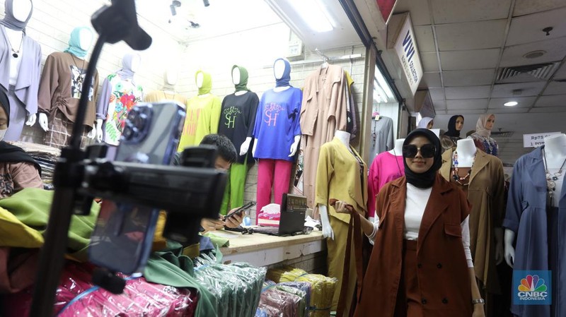 Karyawan mempromosikan pakaian wanita di platfom siaran langsung (live) media sosial di kawasan Pertokoan Tanah Abang, Jakarta Pusat, Kamis (13/10/2022). (CNBC Indonesia/Andrean Kristianto)