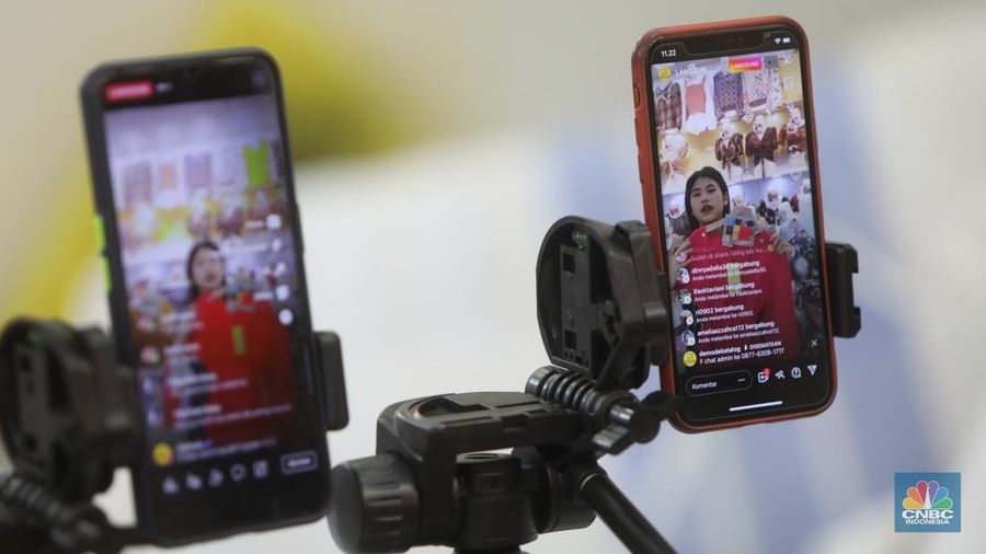 Karyawan mempromosikan pakaian wanita di platfom siaran langsung (live) media sosial di kawasan Pertokoan Tanah Abang, Jakarta Pusat, Kamis (13/10/2022). (CNBC Indonesia/Andrean Kristianto)