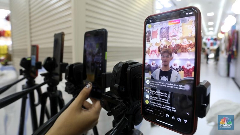 Karyawan mempromosikan pakaian wanita di platfom siaran langsung (live) media sosial di kawasan Pertokoan Tanah Abang, Jakarta Pusat, Kamis (13/10/2022). (CNBC Indonesia/Andrean Kristianto)