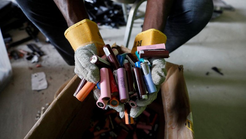 An employee holds a handful of lithium-ion cells from old laptop battery packs at the Quadloop recycling facility in Lagos, Nigeria October 4, 2022. REUTERS/Temilade Adelaja
