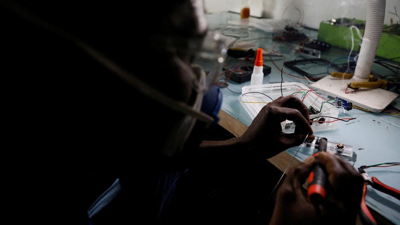 An employee holds a handful of lithium-ion cells from old laptop battery packs at the Quadloop recycling facility in Lagos, Nigeria October 4, 2022. REUTERS/Temilade Adelaja