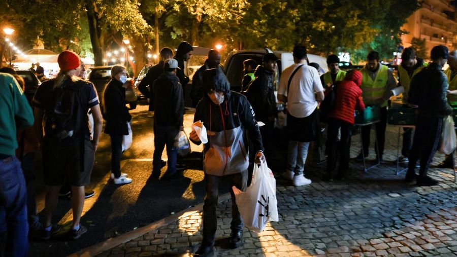 People wait in line to collect food from homeless charity CASA in central Lisbon, Portugal October 11, 2022. REUTERS/Pedro Nunes