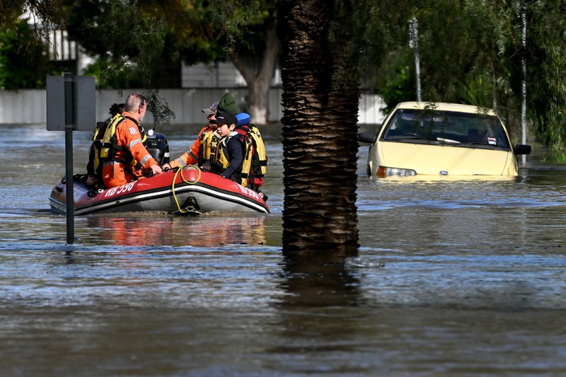 Banjir di Australia Pekerja darurat mengevakuasi warga saat banjir di pinggiran Melbourne, Maribyrnong, Australia, Jumat (14102/2022). Banjir telah menggenangi jalan, memaksa sekolah ditutup, dan memutus aliran listrik ke 3.000 rumah dan bisnis. (Photo by WILLIAM WEST/AFP via Getty Images)